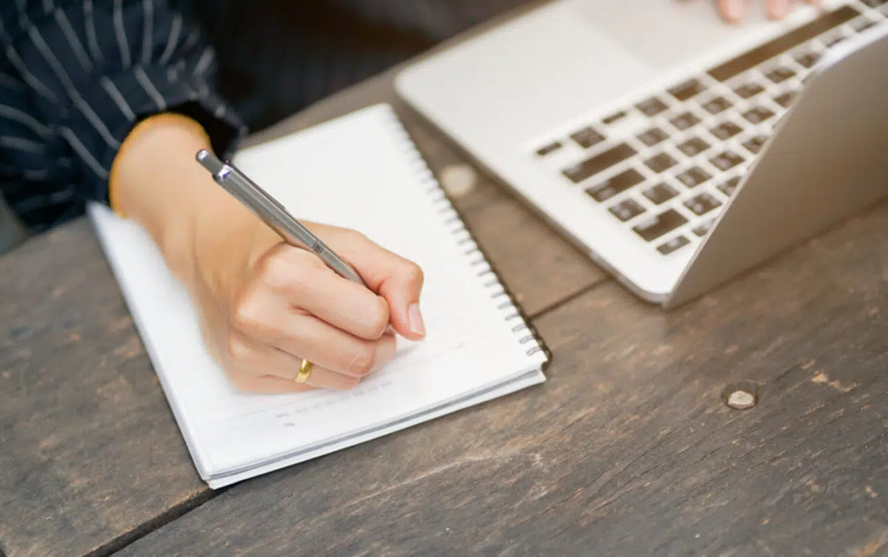 Close,Up,Businesswoman,Hand,Writing,Content,Or,Somethings,On,Notebook